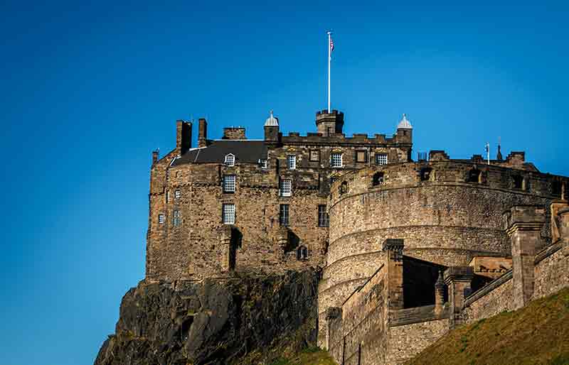 Stone fortification perched high on hillside.