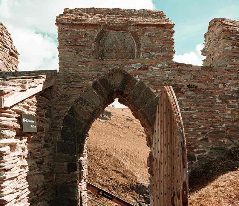 Through an arched doorway in stone-built wall.